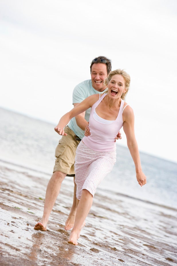 1017049301 Couple running at the beach smiling